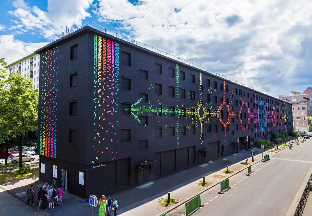 Une fresque composée de 15000 oiseaux en origami recouvre cet immeuble parisien