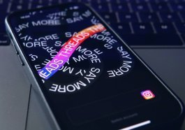 a close up of a cell phone with a keyboard in the background