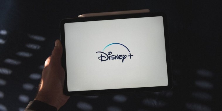 a person holding a tablet with a disney logo on it
