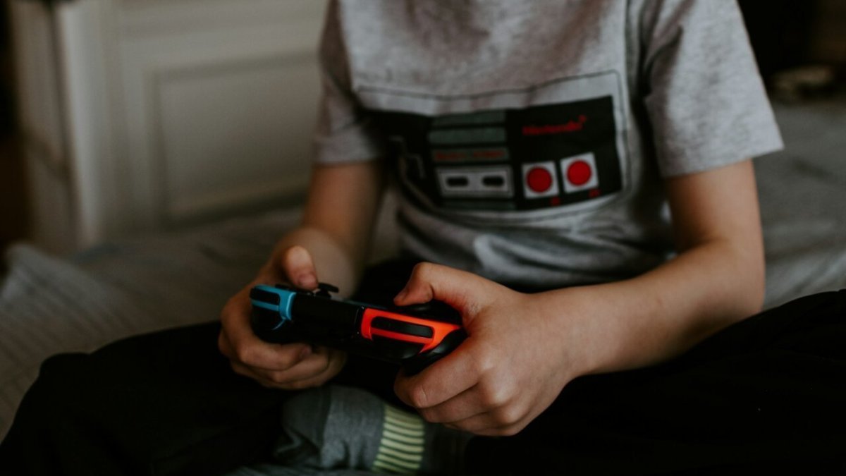 kid sitting on gray bed while playing